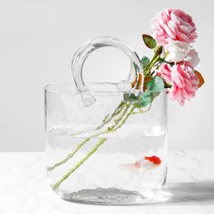 a vase with flowers and a fish in it