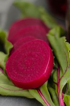 three beets sitting on top of green leaves