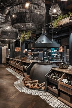 the interior of a restaurant with wooden tables and hanging lights over it's counter