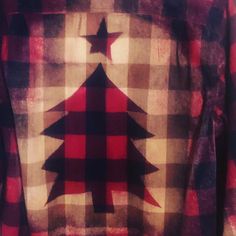 a red and black plaid shirt with a christmas tree on the front, stars in the back