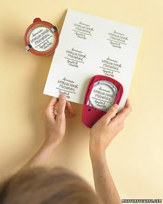 a person holding a pair of scissors next to a piece of paper with writing on it