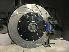 the front brake and disc of a car in a garage with it's brakes on