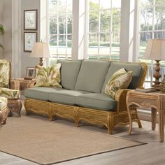 a living room with wicker furniture in it's natural color scheme and large windows