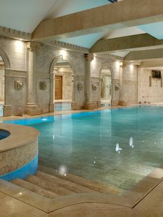 a large indoor swimming pool surrounded by stone steps