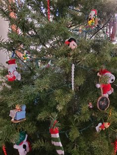 a christmas tree with ornaments hanging from it's branches and decorations on the top