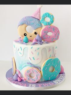 a birthday cake decorated with donuts and sprinkles for a child's first birthday