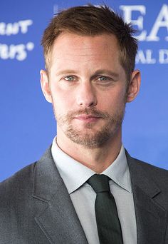 a man in a suit and tie looking at the camera with a serious look on his face