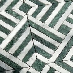 a close up view of a tile floor with green and white designs on it's sides