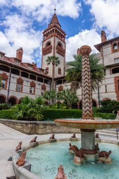 a fountain in front of a large building with two towers on the top of it