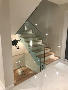 a staircase with glass railing and wooden steps