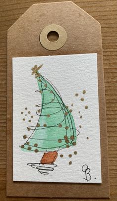 a card with a green christmas tree on it's front and brown tag hanging from the back