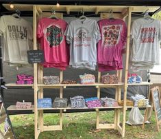 an outdoor clothing stand with t - shirts on display