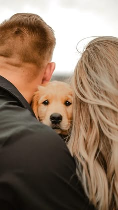 a man and woman holding a dog in their arms