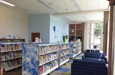 an empty library with blue chairs and bookshelves