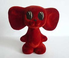 a small red stuffed animal with big eyes