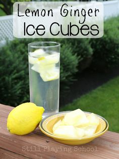 a lemon sitting next to a glass with ice cubes in it on a wooden table