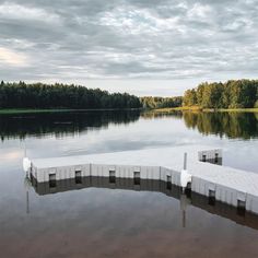 the dock is made out of concrete blocks and sits in the middle of a lake