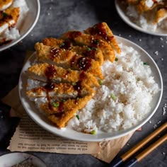 three plates with rice, meat and sauces on them next to chopsticks