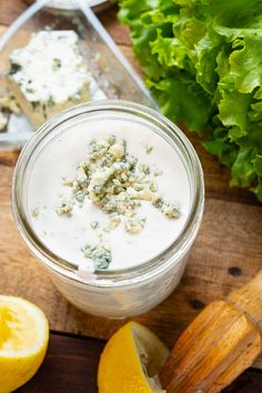 a mason jar filled with yogurt and garnished with chopped green leaves