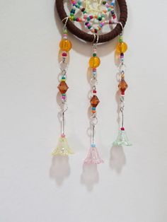 a dream catcher hanging on the wall with beads