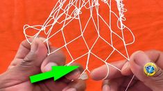 two hands are holding pins in front of a net with an arrow pointing to it