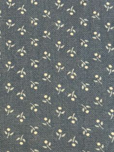 a close up view of a blue fabric with white flowers on it and a black background