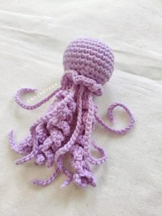 a crocheted octopus is sitting on a white sheet and it looks like it has been made out of yarn