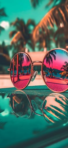 a pair of sunglasses with palm trees reflected in them