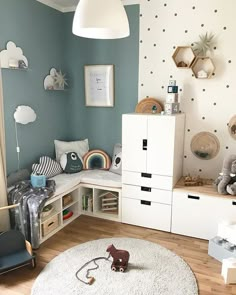 a child's room decorated in blue and white with teddy bears on the wall