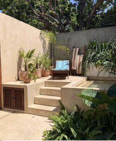 an outdoor patio with steps leading up to the back door and potted plants on either side