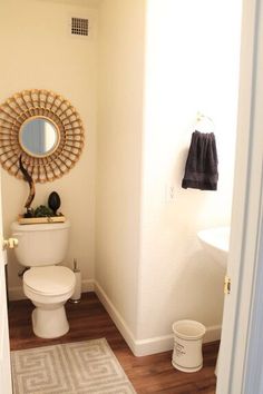 a white toilet sitting in a bathroom next to a sink