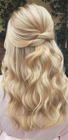 the back of a woman's head with long blonde hair in a half - updo