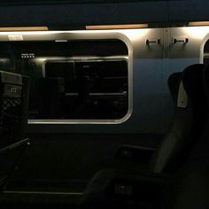 an empty train car with the lights on and no people in it at night time