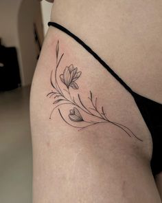 a woman's stomach with a flower tattoo on her left side ribcage