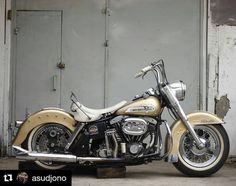 a tan and black motorcycle parked in front of a building