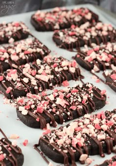 chocolate cookies with sprinkles and pink and white confetti on top