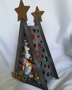 a wooden christmas tree with three stars on top