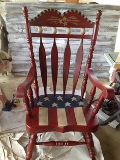 a red wooden rocking chair with an american flag painted on it