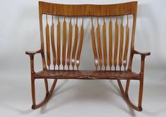 a wooden rocking chair with long slats on the back