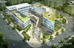 an aerial view of a large building with lots of green roofing and trees around it