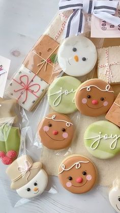 some decorated cookies sitting on top of a table next to wrapping paper and other items