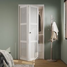 a bedroom with green walls and a white closet next to a bed in the corner