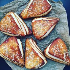 six pastries are arranged on a piece of wax paper