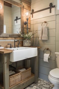 a white sink sitting under a bathroom mirror next to a wooden counter top with baskets underneath it