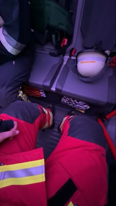 two firemen in red and yellow uniforms sitting on the back of an airplane seat