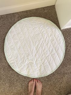 a person standing in front of a round mat on the floor with their feet up