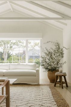 a living room filled with furniture and a large white couch next to a wooden table