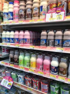 many different types of drinks are on display in a grocery store, including milk and yogurt