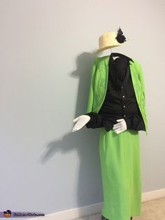 a mannequin dressed in green and black with a hat on it's head