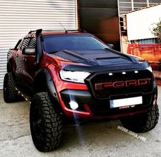 a red truck parked in front of a garage